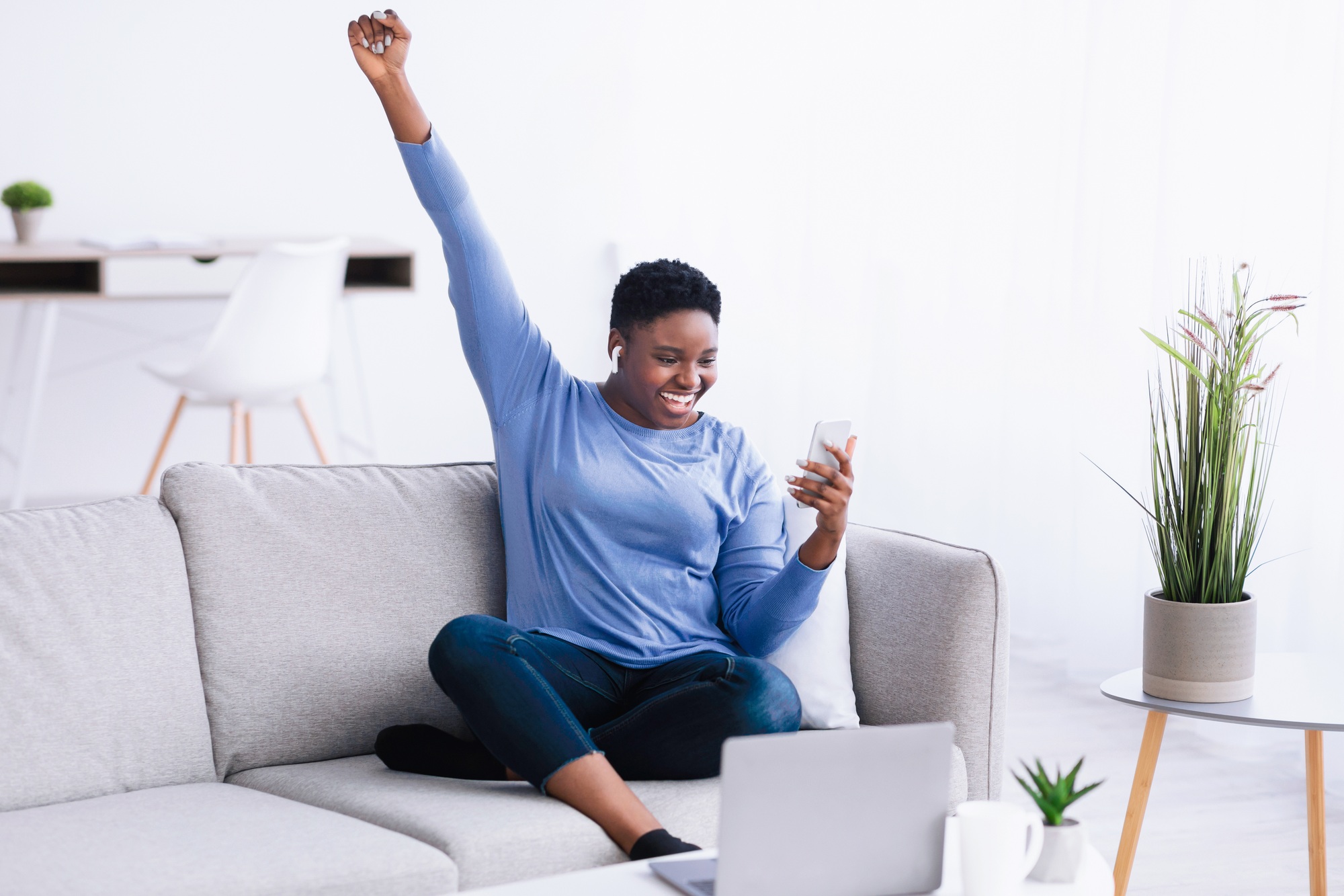 Black lady wearing headphones enjoying music with phone